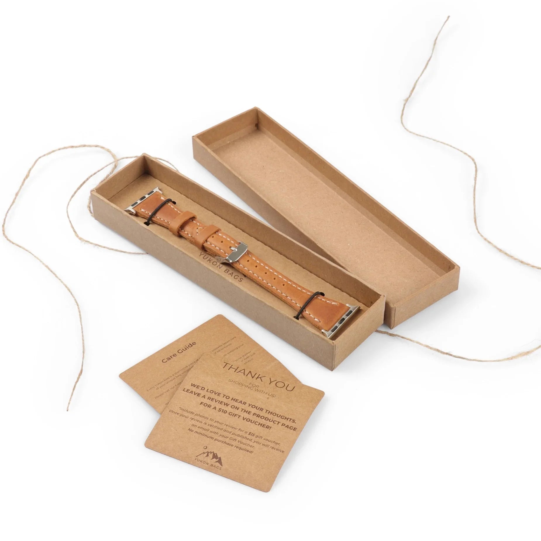 Tan full-grain leather watch strap with metal buckle in gift box, includes care guide cards